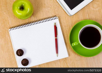 Work place. Tablet pc cup of coffee and notepad at table