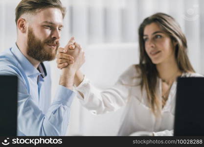 Work Relationship. Young Male and Female colleagues in Love at Work. Holding hands in the office.. Love Relationship at Work. Office Colleagues Having a Romantic Affair