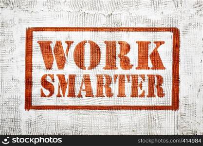work smarter - red graffiti style sign on a white stucco wall