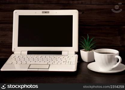 Work space at home. Laptop and coffee cup on a wooden background. Place for text.. Work space at home. Laptop and coffee cup on wooden background. Place for text.