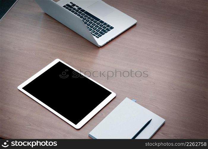 work station open laptop with blank screen digital tablet on wooden desk