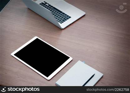 work station open laptop with blank screen digital tablet on wooden desk
