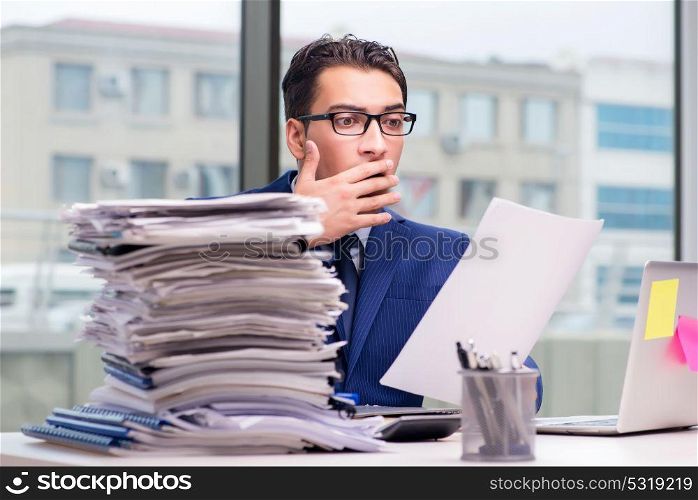 Workaholic businessman overworked with too much work in office