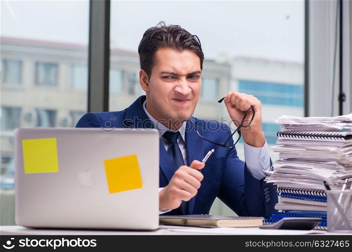 Workaholic businessman overworked with too much work in office