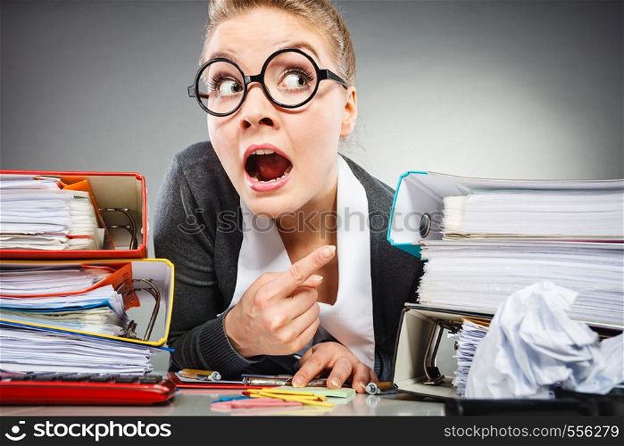 Workaholism mental insanity weird job work company concept. Insane office woman at work. Mad secretary making silly expression lurking through her desk.. Insane office woman at work.