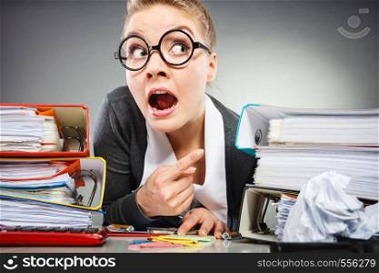 Workaholism mental insanity weird job work company concept. Insane office woman at work. Mad secretary making silly expression lurking through her desk.. Insane office woman at work.