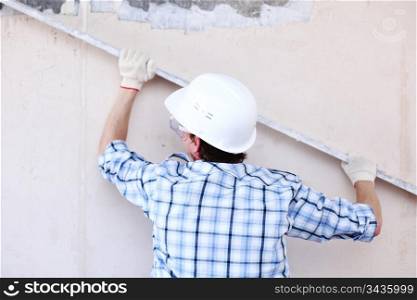 worker aligns wall for directing