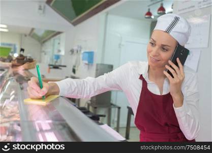 worker at a butchery using mobile phpe
