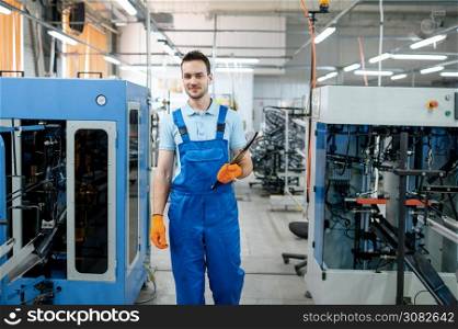 Worker at the assemly line checks bicycle wheels on factory. Bike rims and spokes production in workshop, cycle parts installation, modern technology. Worker at the assemly line checks bicycle wheels