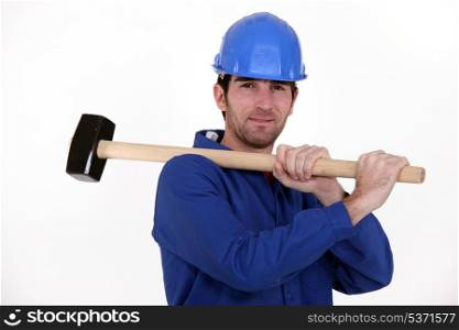 Worker carrying a mallet on his shoulder