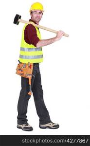 Worker carrying sledge-hammer over shoulder