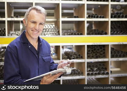 Worker Checking Stock Levels In Store Room