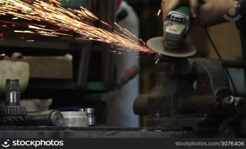 Worker cutting metal with a metal grinding sparks and bokeh. Spark spray from grinder cutting metal.
