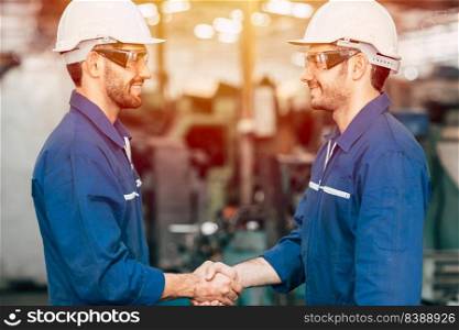 Worker engineer team smiling handshake for finish working dealing job done in factory industry background.