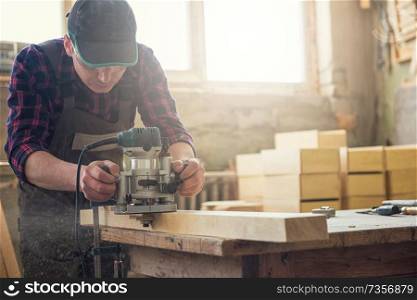 Worker grinds the wood box of angular grinding machine. Profession, carpentry and woodwork concept.. Worker grinds the wood box