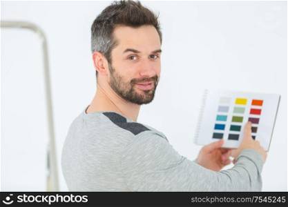 worker holding palette for choosing color of wall