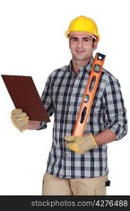 Worker holding spirit level and clip-board
