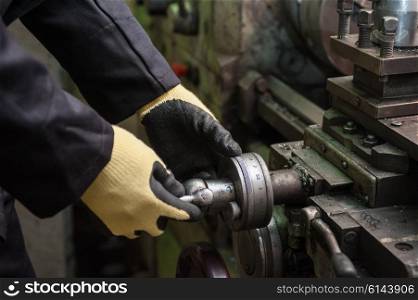 worker in protective gloves. worker in protective gloves in factory using machine