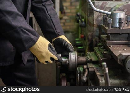 worker in protective gloves. worker in protective gloves in factory using machine