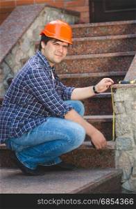 Worker in red helmet repairing old stone staircase