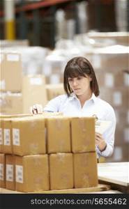 Worker In Warehouse Preparing Goods For Dispatch