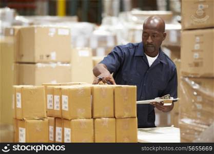 Worker In Warehouse Preparing Goods For Dispatch