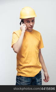 Worker in yellow helmet calling by phone