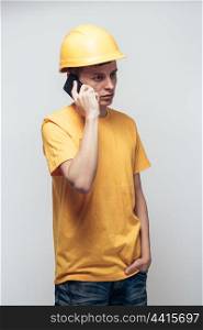 Worker in yellow helmet calling by phone