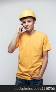 Worker in yellow helmet calling by phone