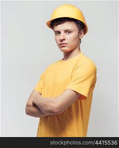 Worker in yellow helmet standing with arms crossed