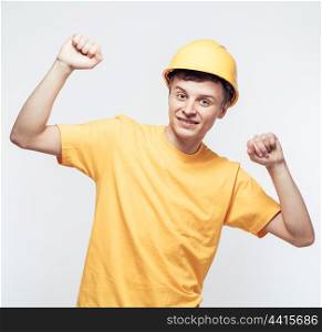 Worker in yellow helmet with joyful hands raised