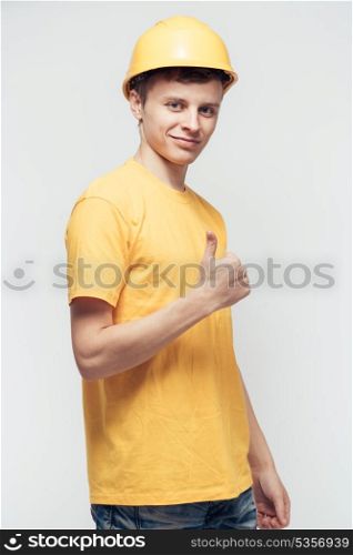 Worker in yellow helmet with joyful hands raised