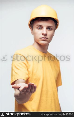 Worker in yellow helmet with outstretched arm