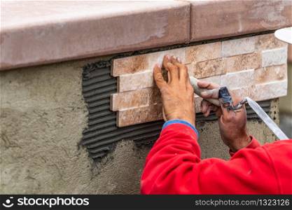 Worker Installing Wall Tile at Construction Site.