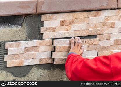 Worker Installing Wall Tile at Construction Site.