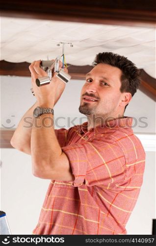 Worker is installing a luster in a Haus on the ceiling