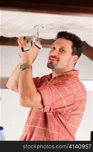 Worker is installing a luster in a Haus on the ceiling