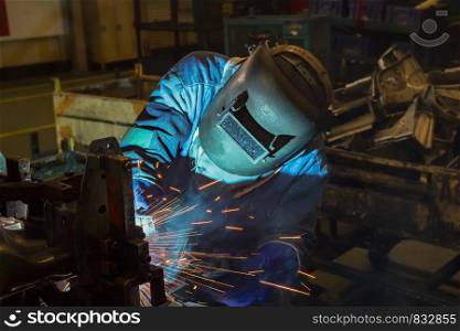 Worker is welding in factory