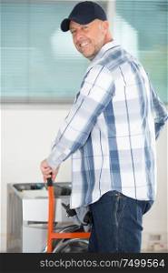 worker looking at camera after carrying washing machine