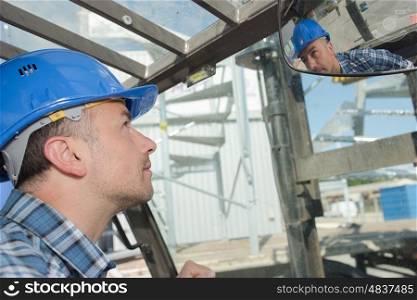 worker looking at rear view mirror
