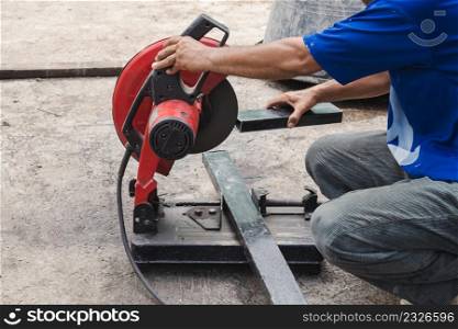 Worker man cutting steel with a circular steel cutter.