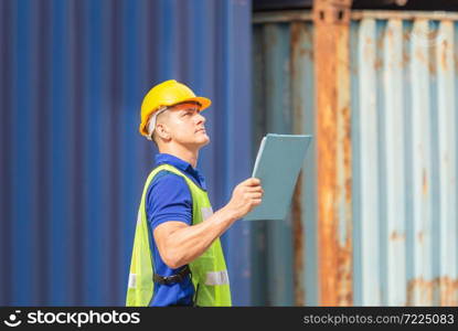 Worker man holding clipboard checklist and checking containers box from cargo