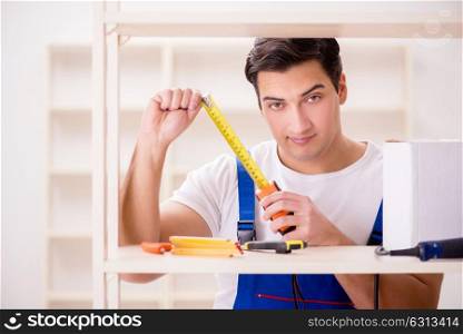 Worker man repairing assembling bookshelf