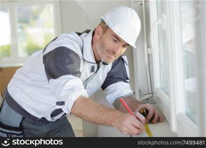 worker measuring at window length