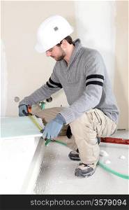 Worker measuring plasterboard