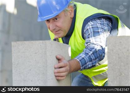 worker moving a concrete block