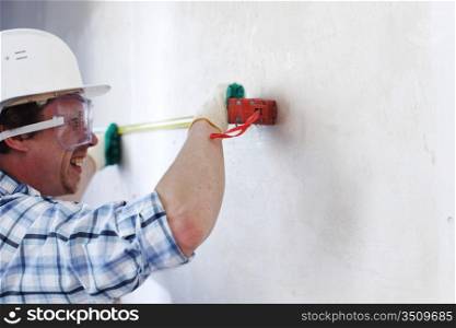 worker often with a measuring tape to the wall