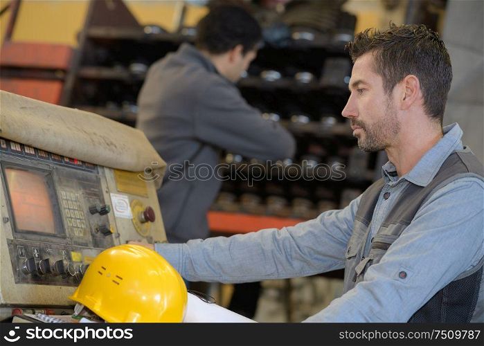 worker operating the control panel of an industrial machinery