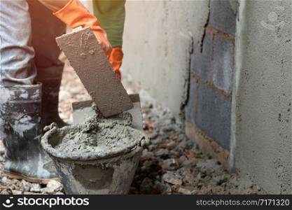 worker plastering cement on wall for building house