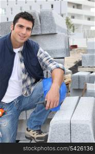 Worker posing with stacks of concrete blocks